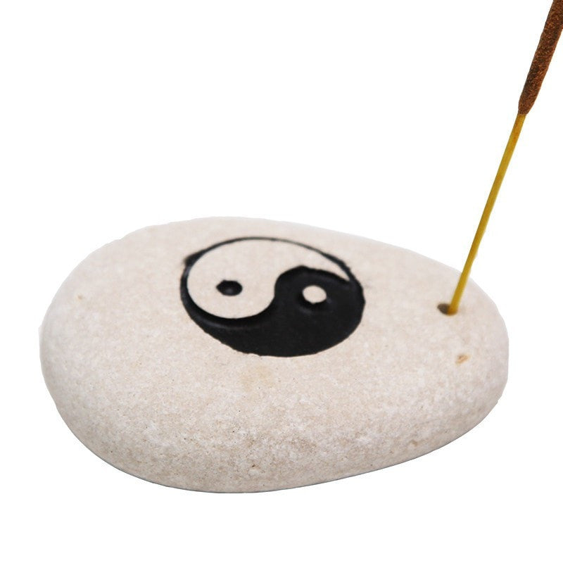 Stone incense holder with yin yang carved into top and painted and small hold drilled to one side to hold an incense stick 