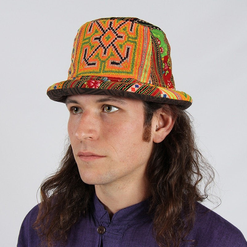 Rolled brim trilby style hat in traditional Thai Hill Tribe material, patterned and striped in different oranges, greens, yellows and browns. - modelled 