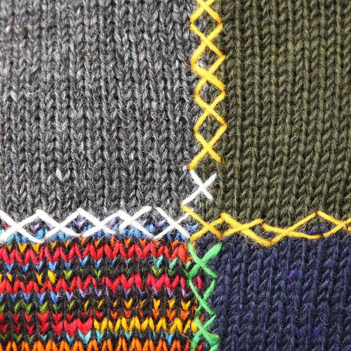 Close up of patches, knitted grey, green, rainbow and navy patches with bright stiching