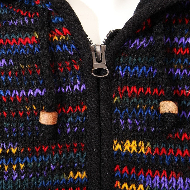 Close up of zip and toggles on zip up woollen hooded coat with fleece lining, overall colouring is black with rainbow streaks running through.
