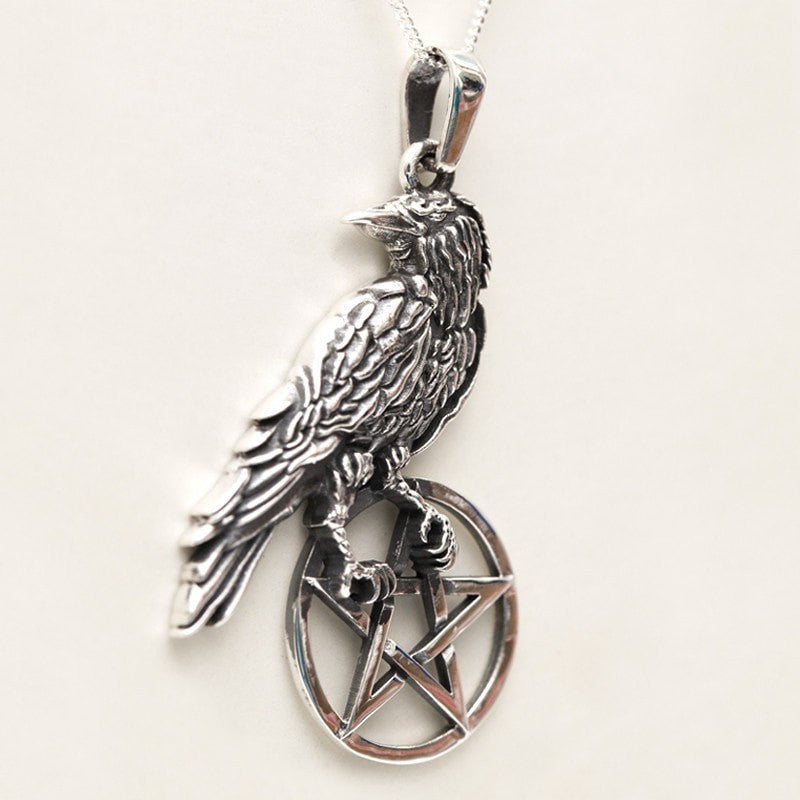 Raven bird sitting on a pentagram pendant silver