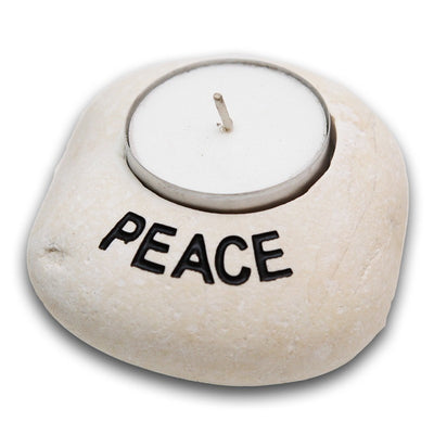 Candle holder made of a smooth grey stone with peace painted round the edge of the carved our area for the tea light.